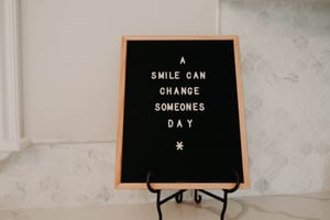 A smile can change someones day writing on a sign