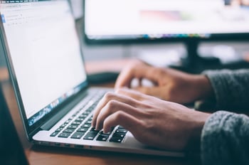 two hands on a laptop typing