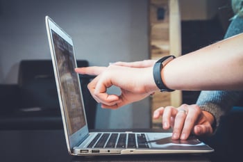 two people working at a laptop