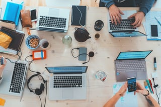 Laptops, phones and headphones on a desk