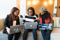 three people using laptops working together closely