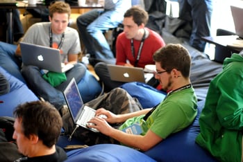 group of people working on laptop sitting on bean bags