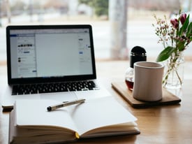 Desk with laptop, journal, pen and coffee